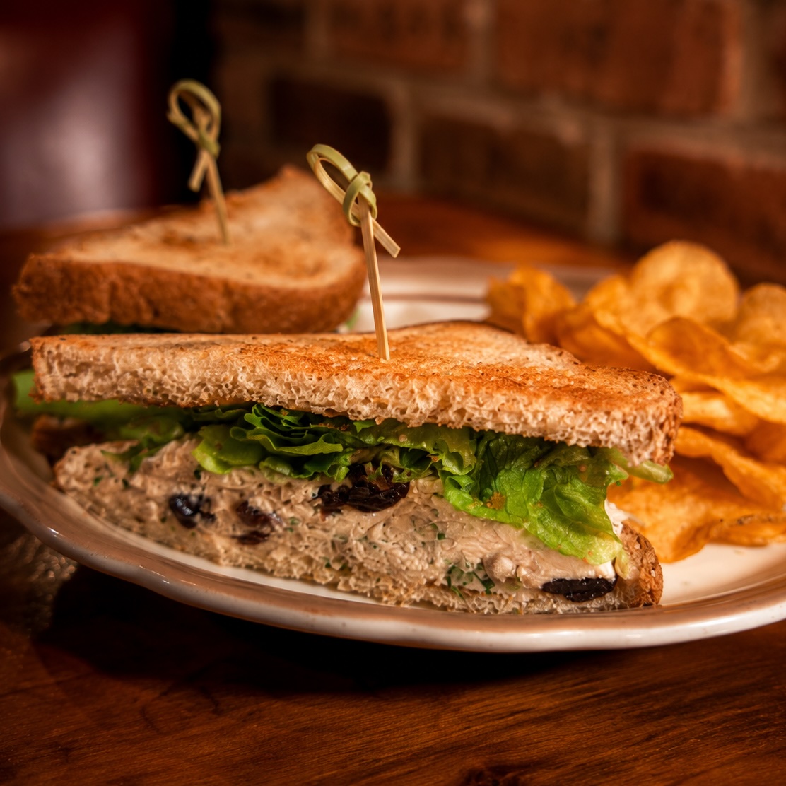 Chicken salad sandwich with dried cherries, celery and fresh greens
